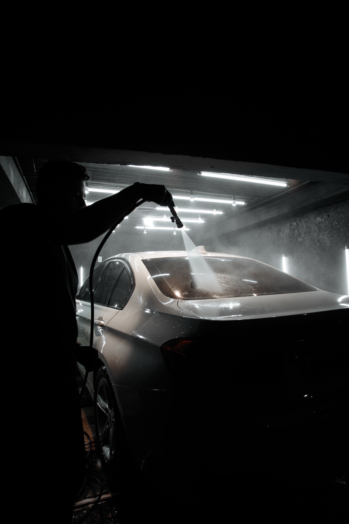 Rinsing down a car in the wash bay
