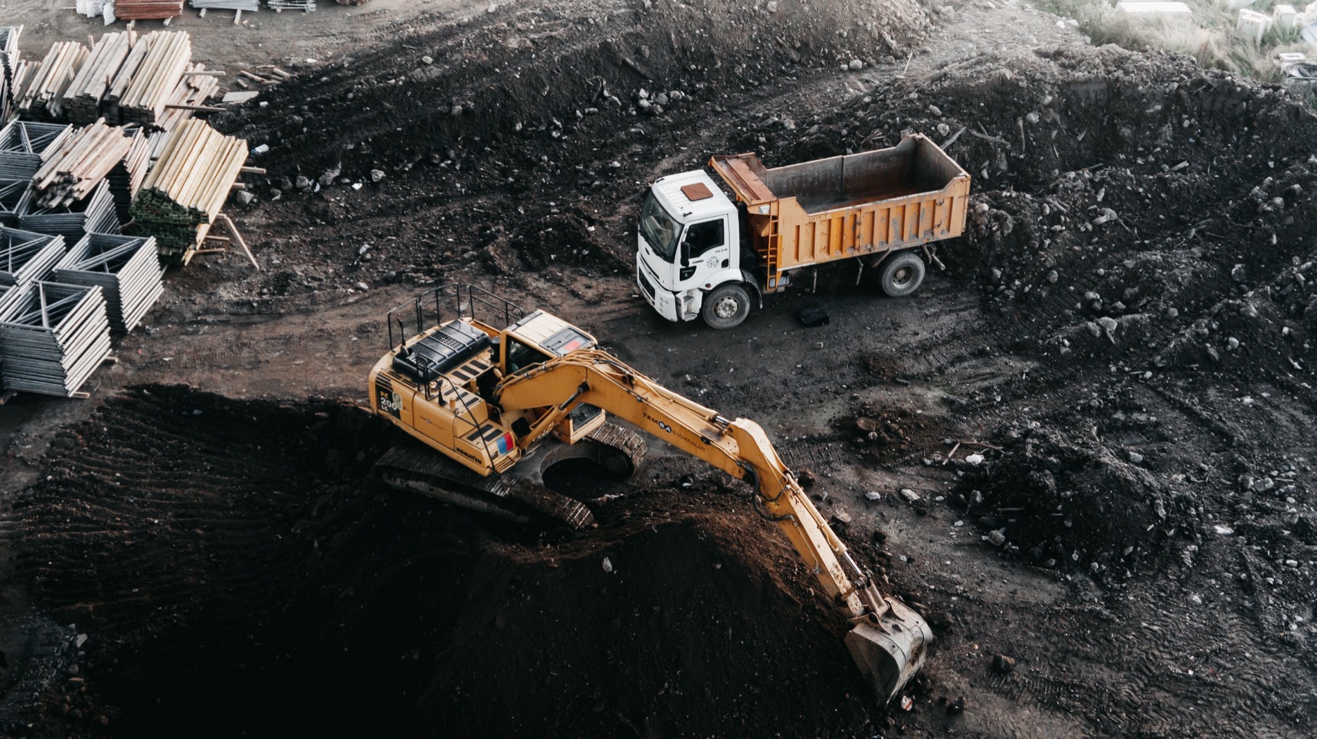 Excavator loading a tiper on a site, seen from above